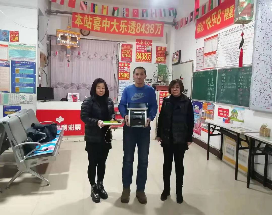 9崔焕琦与两位销售员与打出8438万元中奖彩票的终端机合影.jpg